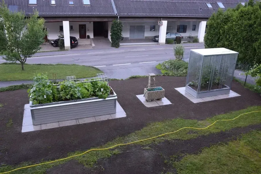 Verschiedene Hochbeete und Tomatenhaus im Garten von Wolfgang und Tina