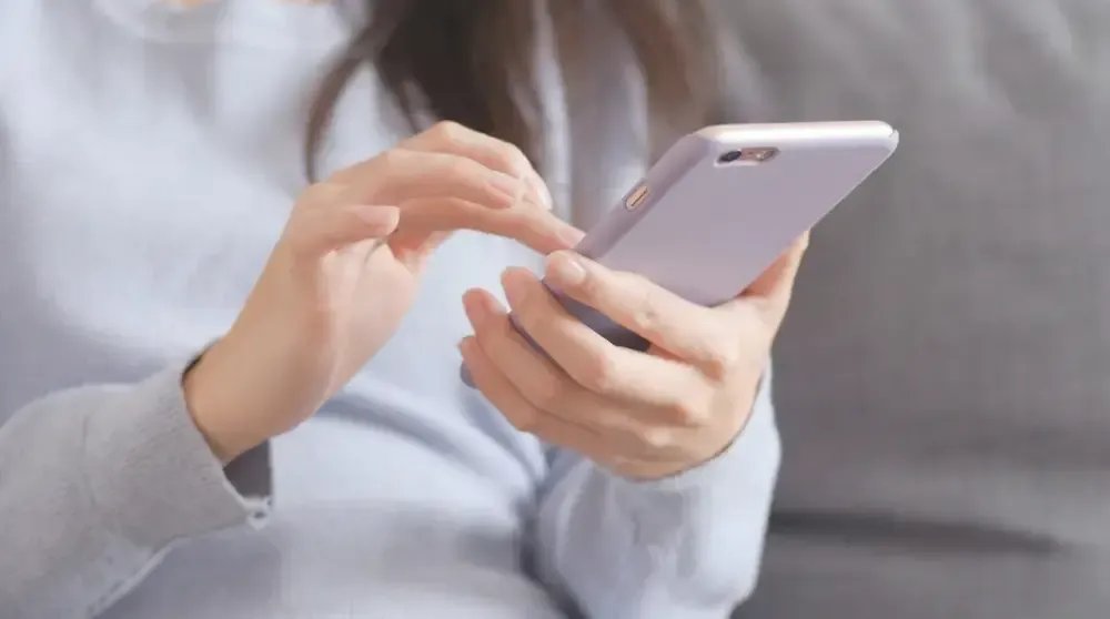 Frau sucht am Smartphone nach Inspiration zur Gartengestaltung