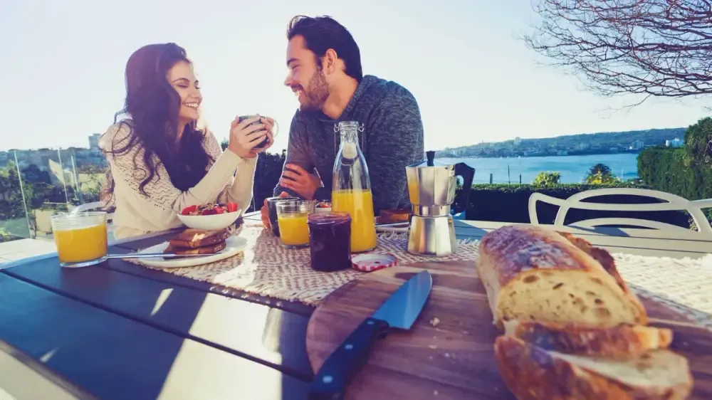 Paar frühstückt gemeinsam im Freien auf der Terrasse